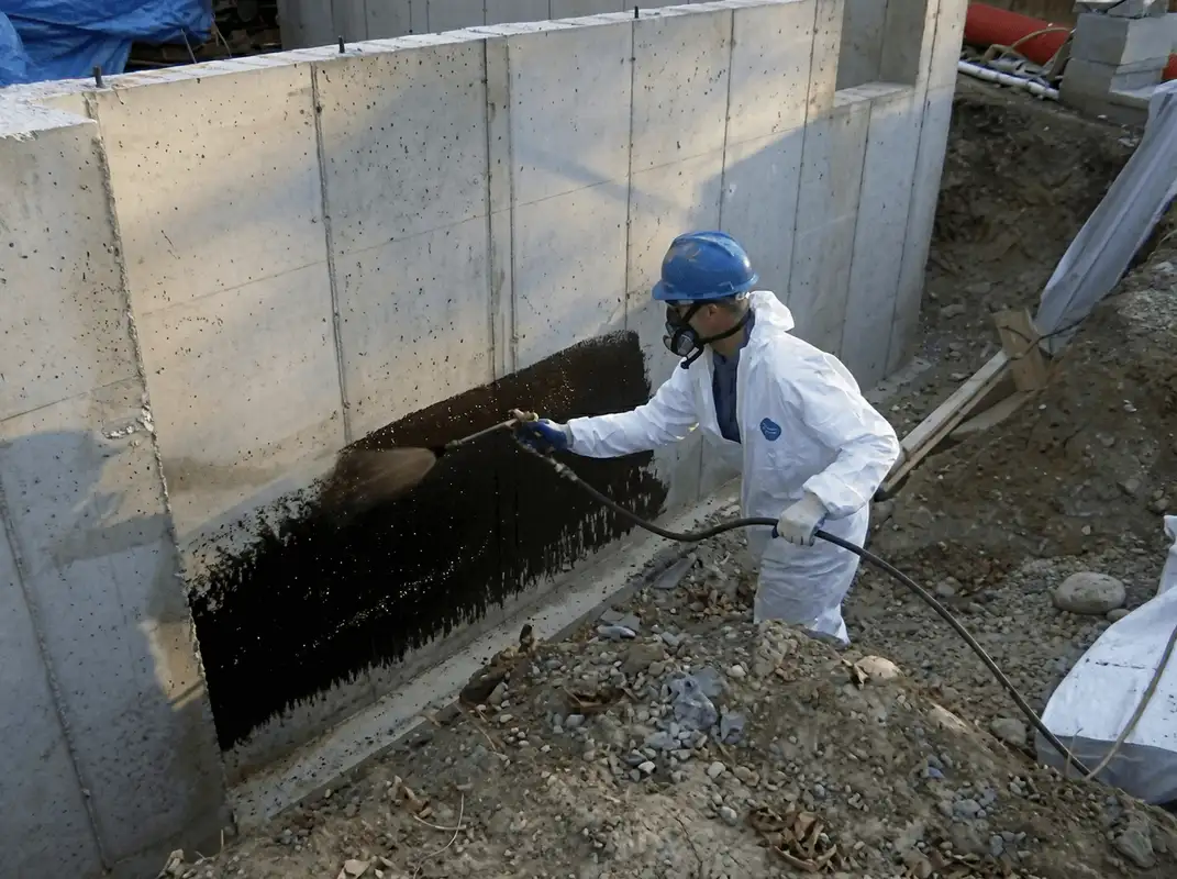 Professional waterproofing the exterior walls of the basement in Tacoma, WA